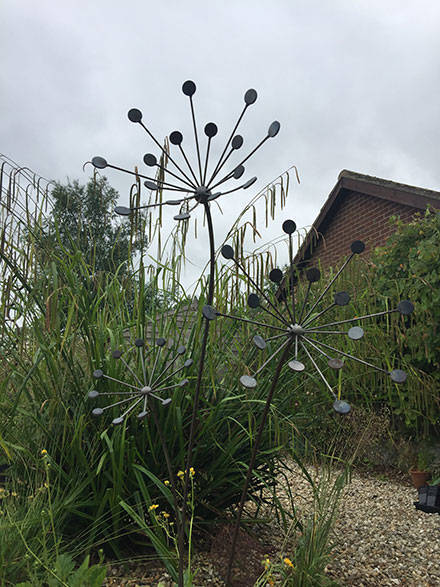 bare steel penny plant sculpture in garden