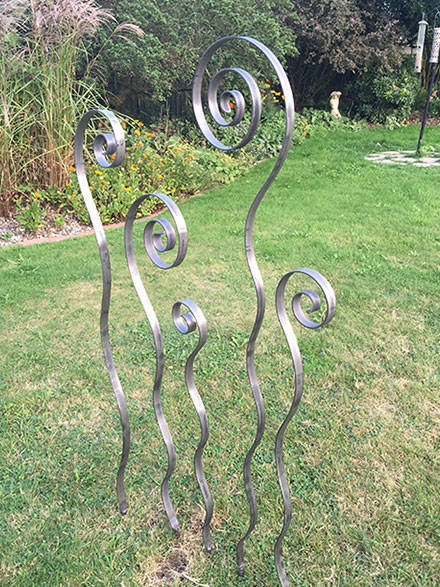 bare steel sculptures  representing ferns unfurling